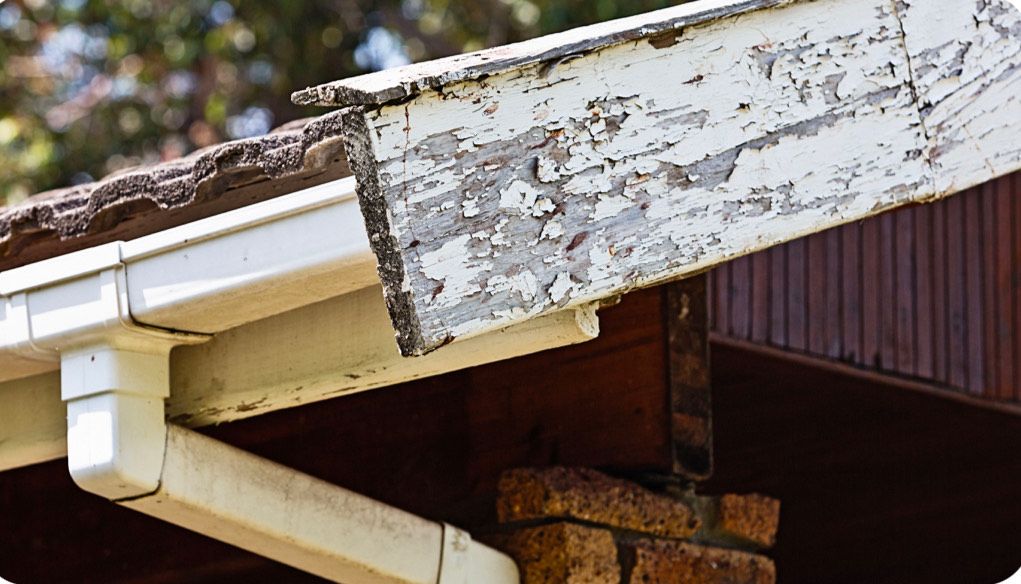 A Gutter on The Side of A House with Peeling Paint.