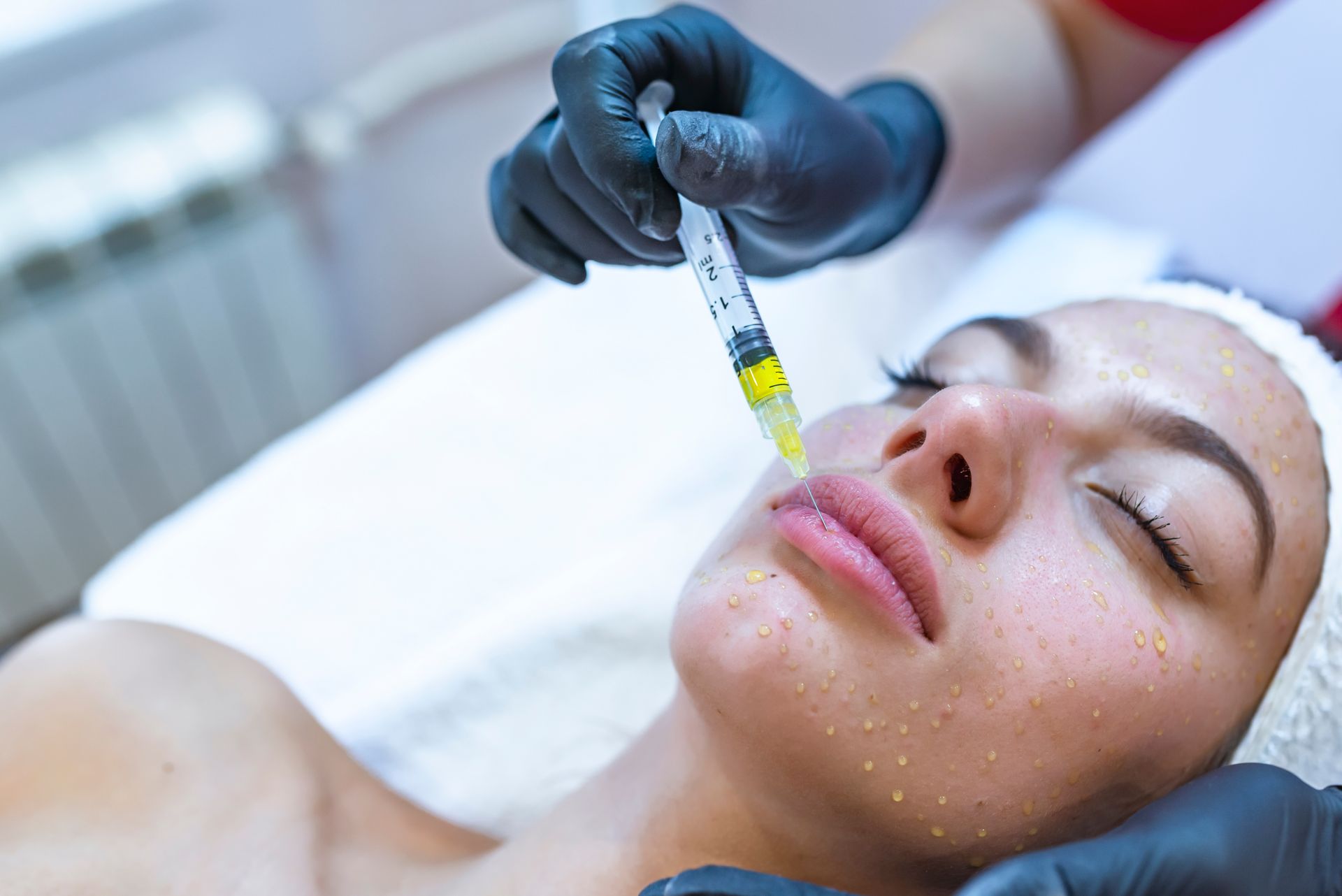 A woman is getting a botox injection in her face.