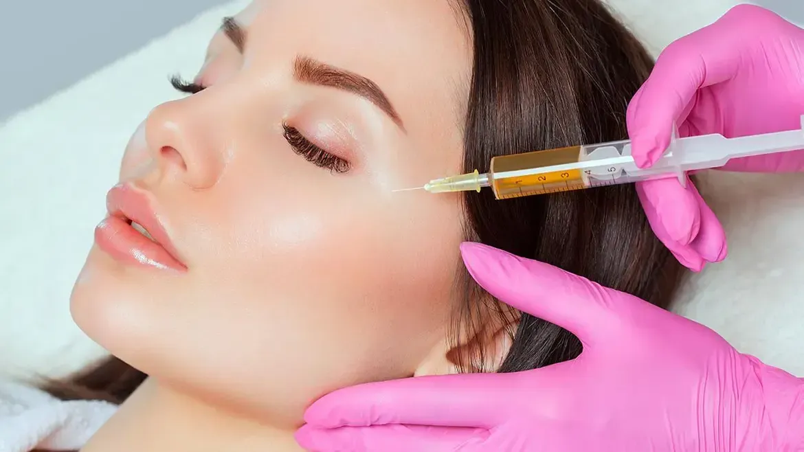 A woman is getting a botox injection in her face.