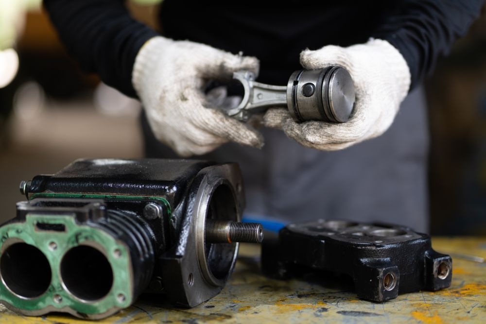 Person in Gloves Holding a Piston and Connecting Rod — Motorhead Garage in Tweed Heads, QLD