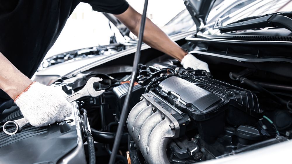 Mechanic With a Wrench Working on a Car Engine Under the Open Hood — Motorhead Garage in Tweed Heads, QLD