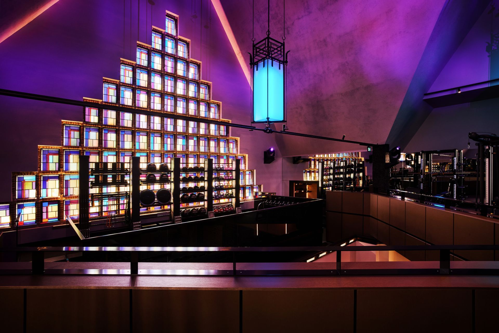 Getrapte, verlichte display tegen een paars verlichte muur in een modern interieur, met stadslichten die buiten zichtbaar zijn.