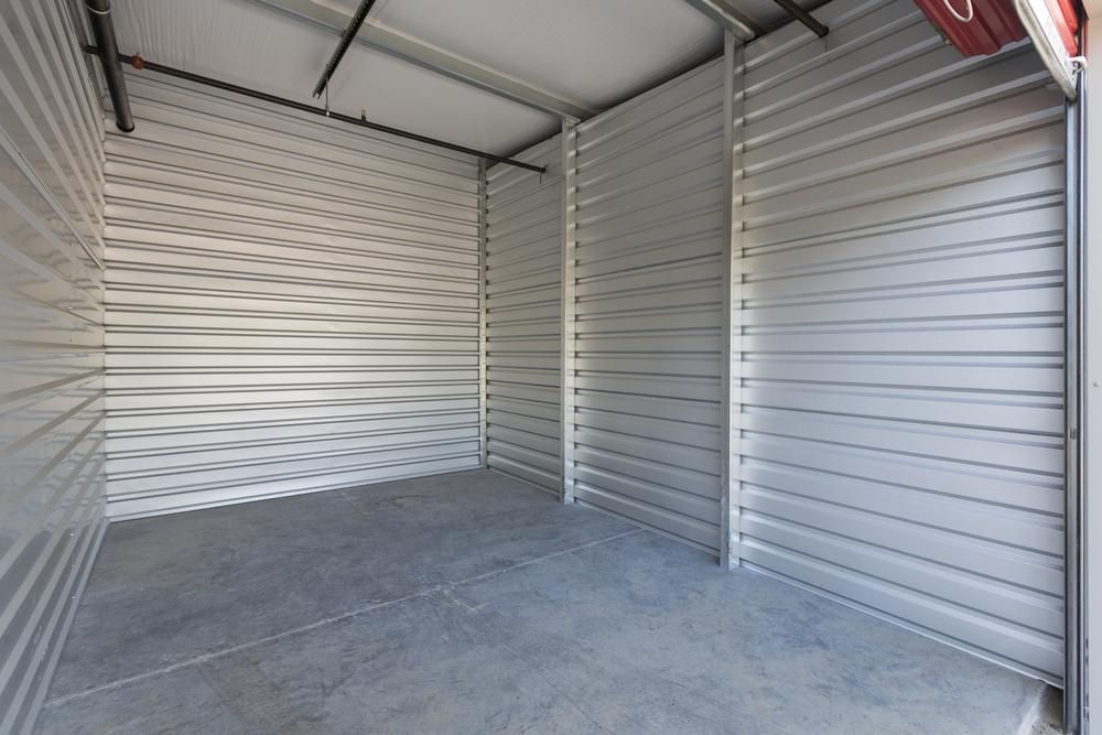An Empty Storage Room With A Concrete Floor And Metal Walls — Raymond Terrace Public Storage In Fern Bay, NSW