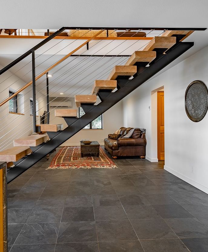 A living room with a staircase leading up to the second floor
