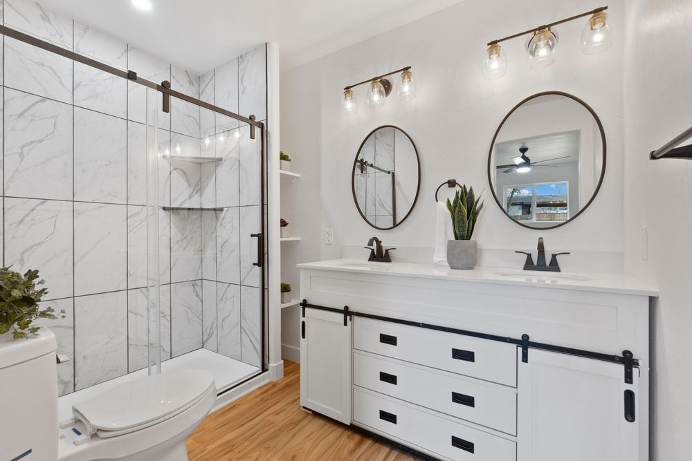 A bathroom with a toilet , sink , and mirrors.