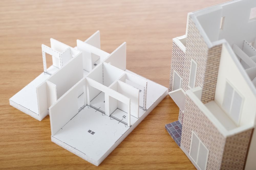 A model of a house is sitting on a wooden table.