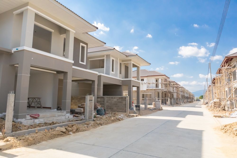 A row of houses are being built in a residential area.