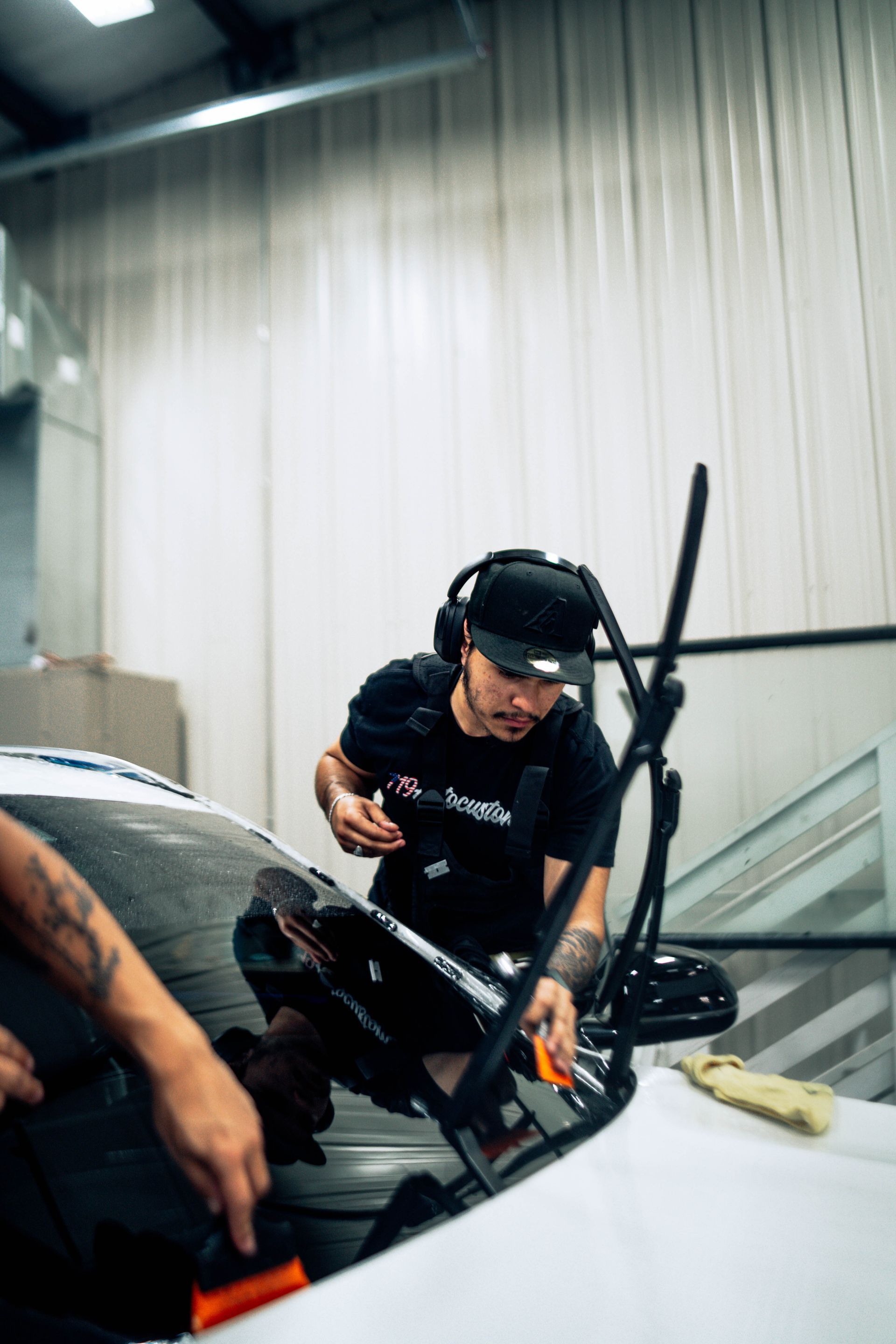 Mechanic working on a white race car inside a workshop