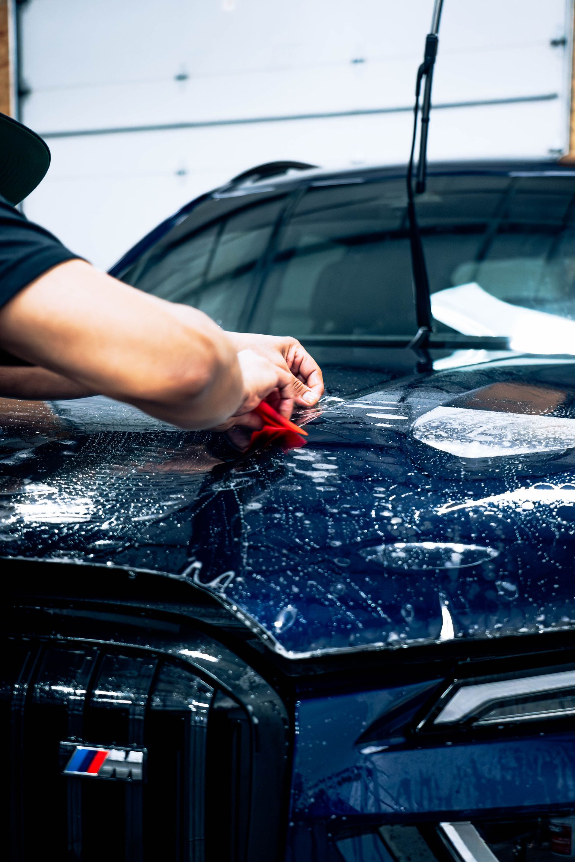 Paint protection film being applied to a hood