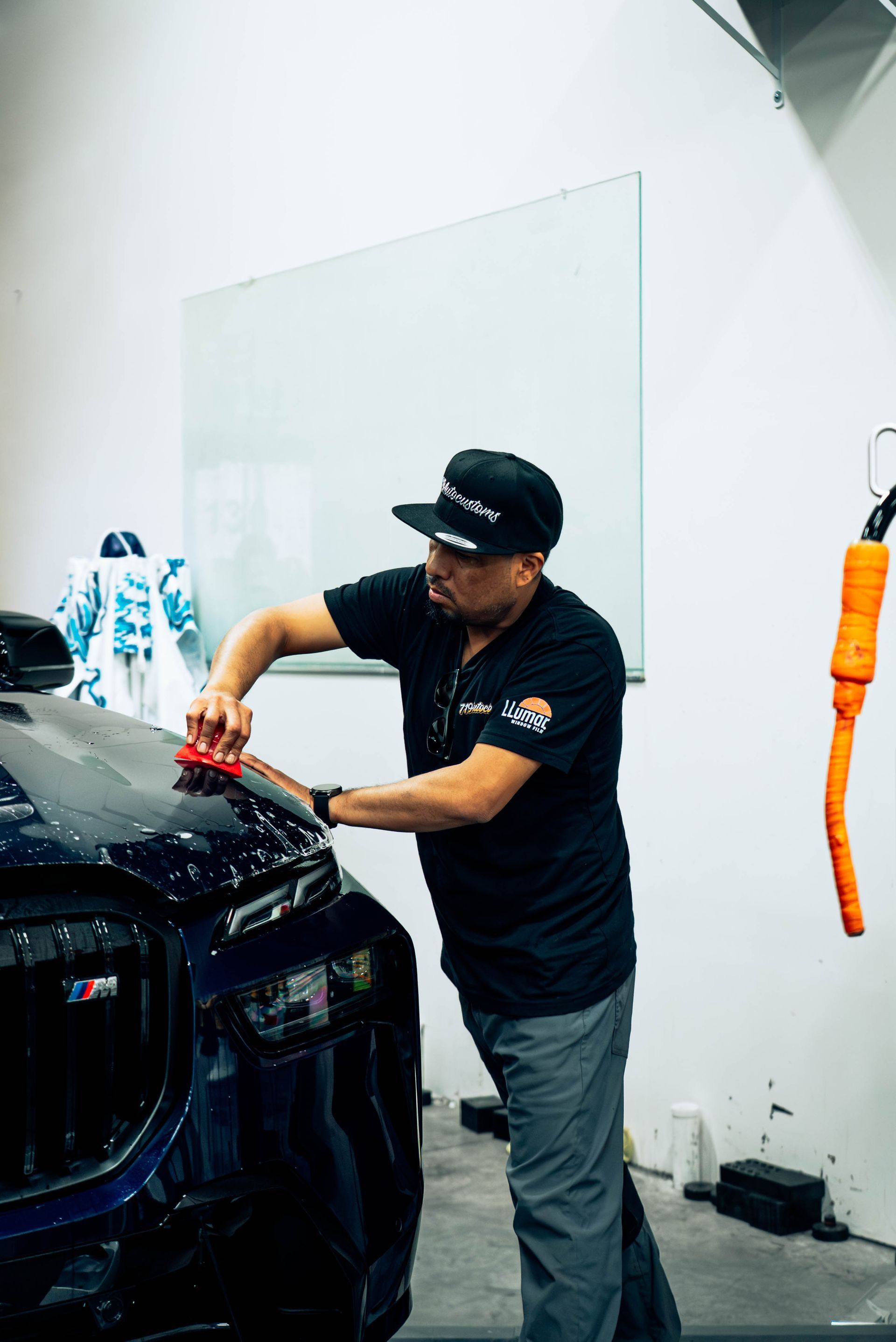 Installer fitting film to a hood during a paint protection film install