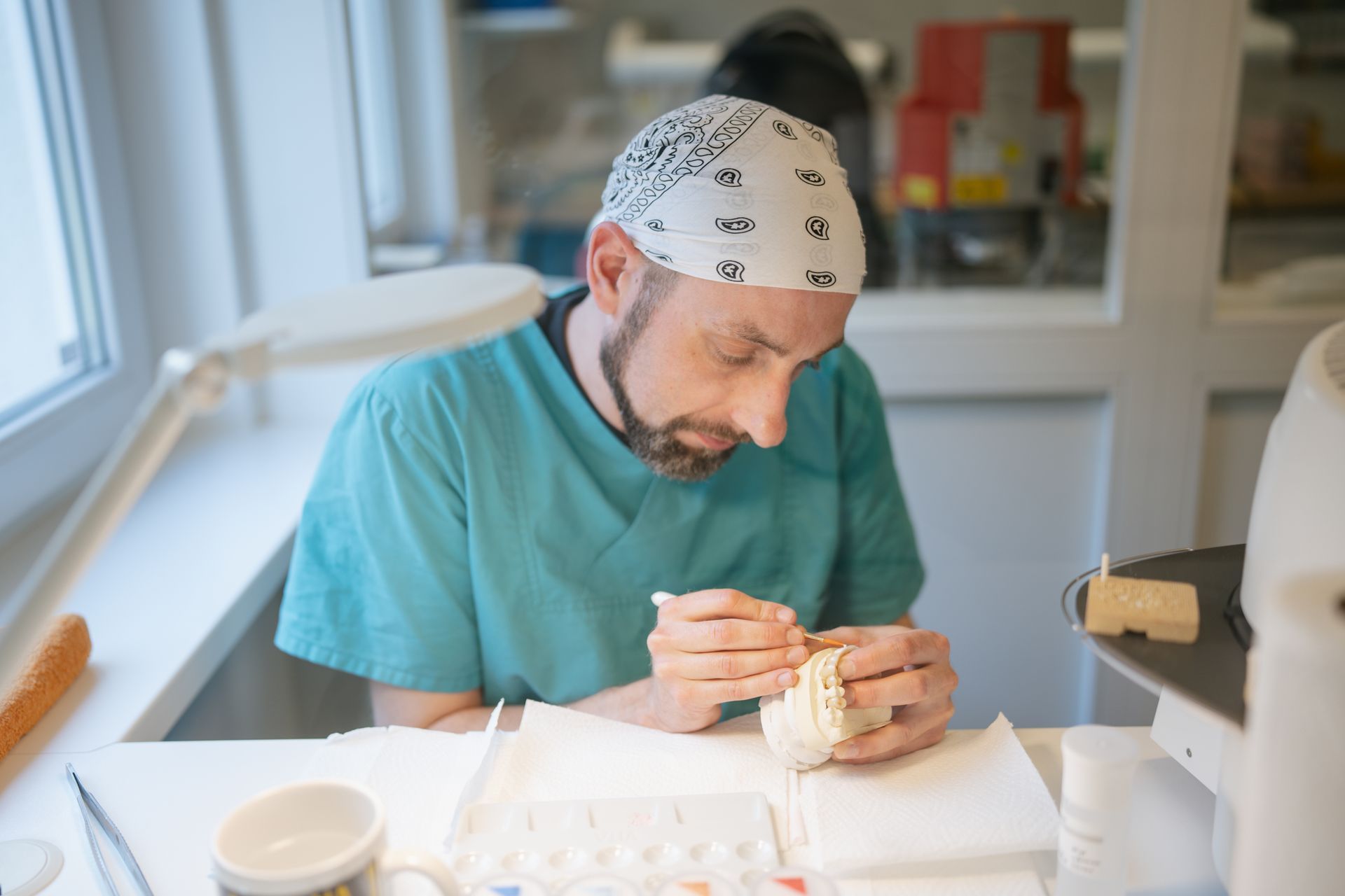 Zahntechniker bemalt Keramik