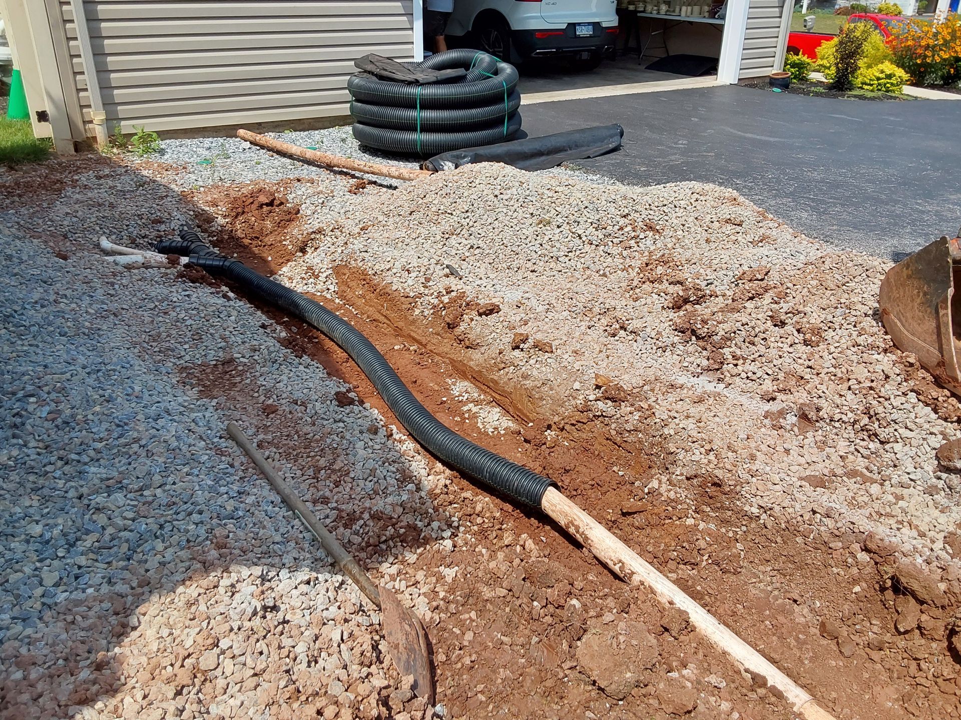 a hose is laying in the dirt next to a shovel