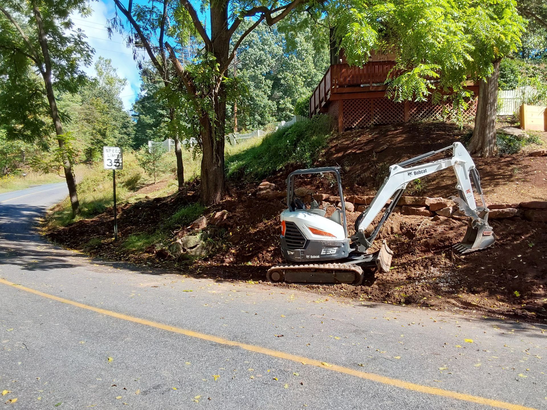 a small excavator is parked on the side of the road next to a house