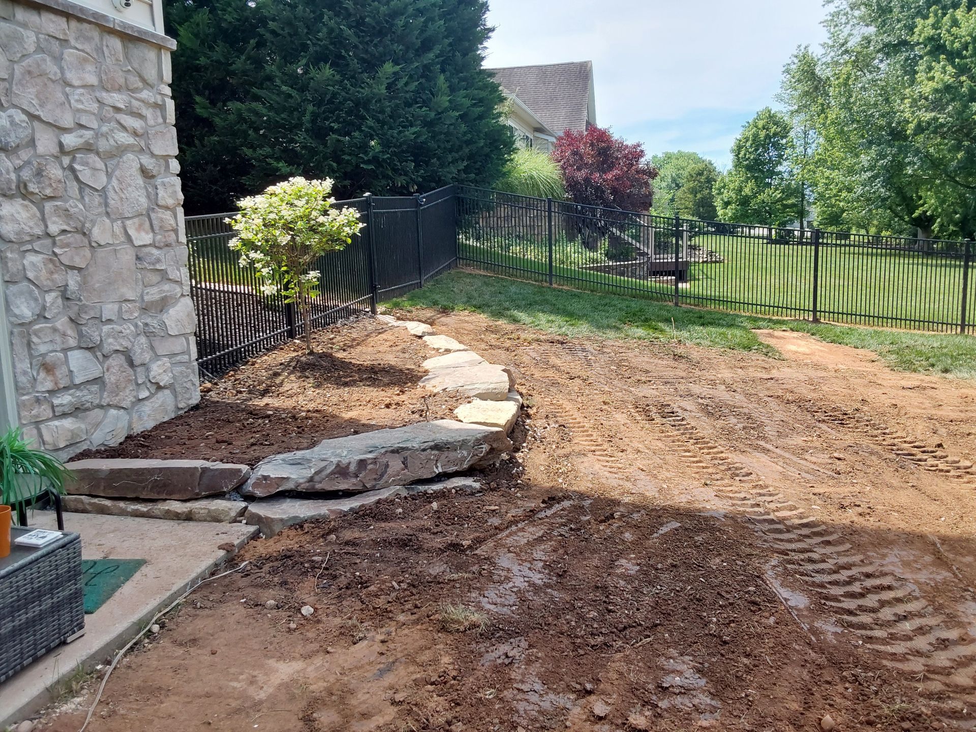 a dirt road with a stone wall in the background