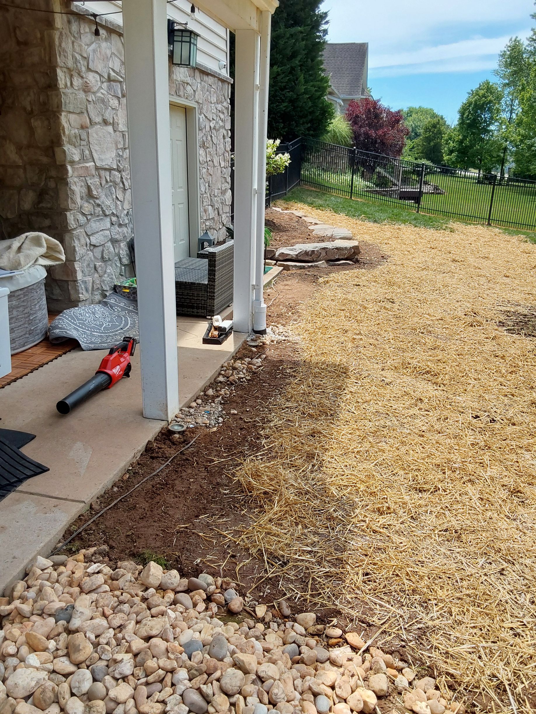 a blower is sitting on a porch next to a pile of mulch