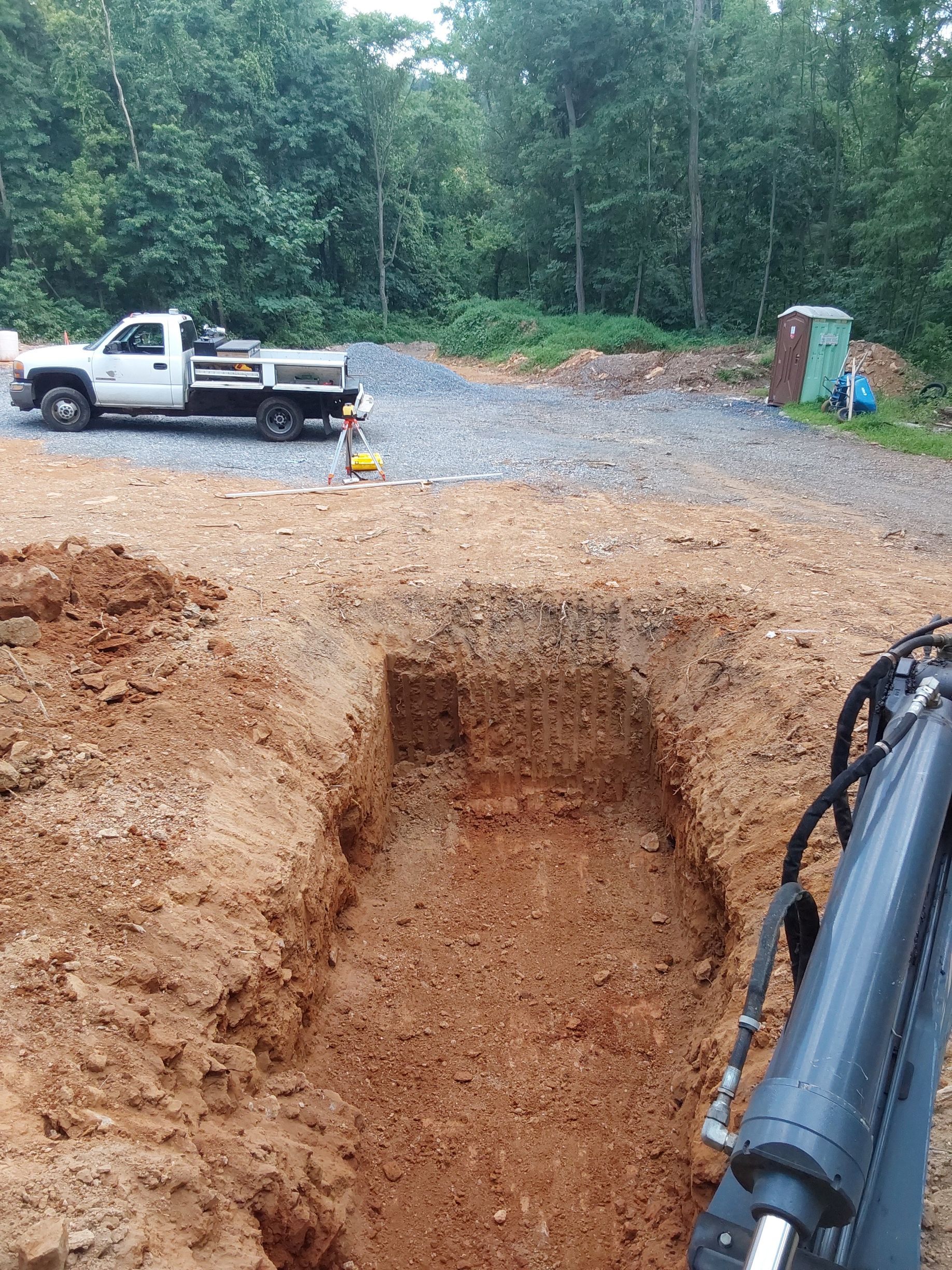 a white truck is parked next to a large hole in the ground