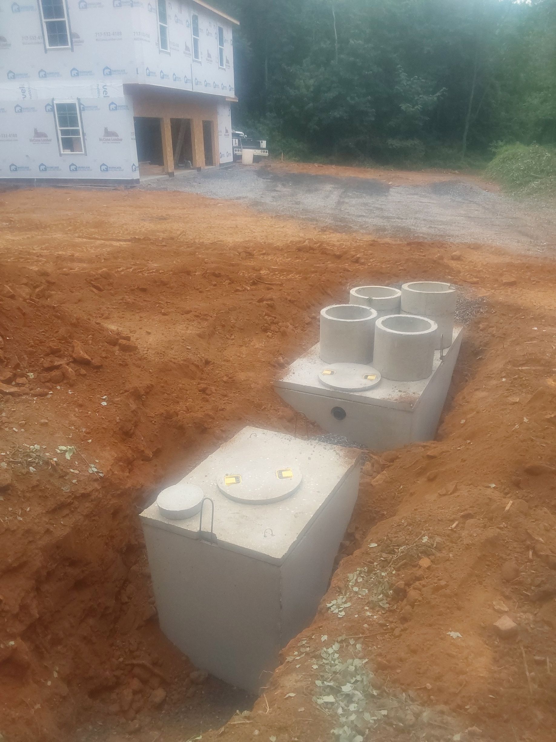 a septic tank is sitting in the dirt in front of a house under construction