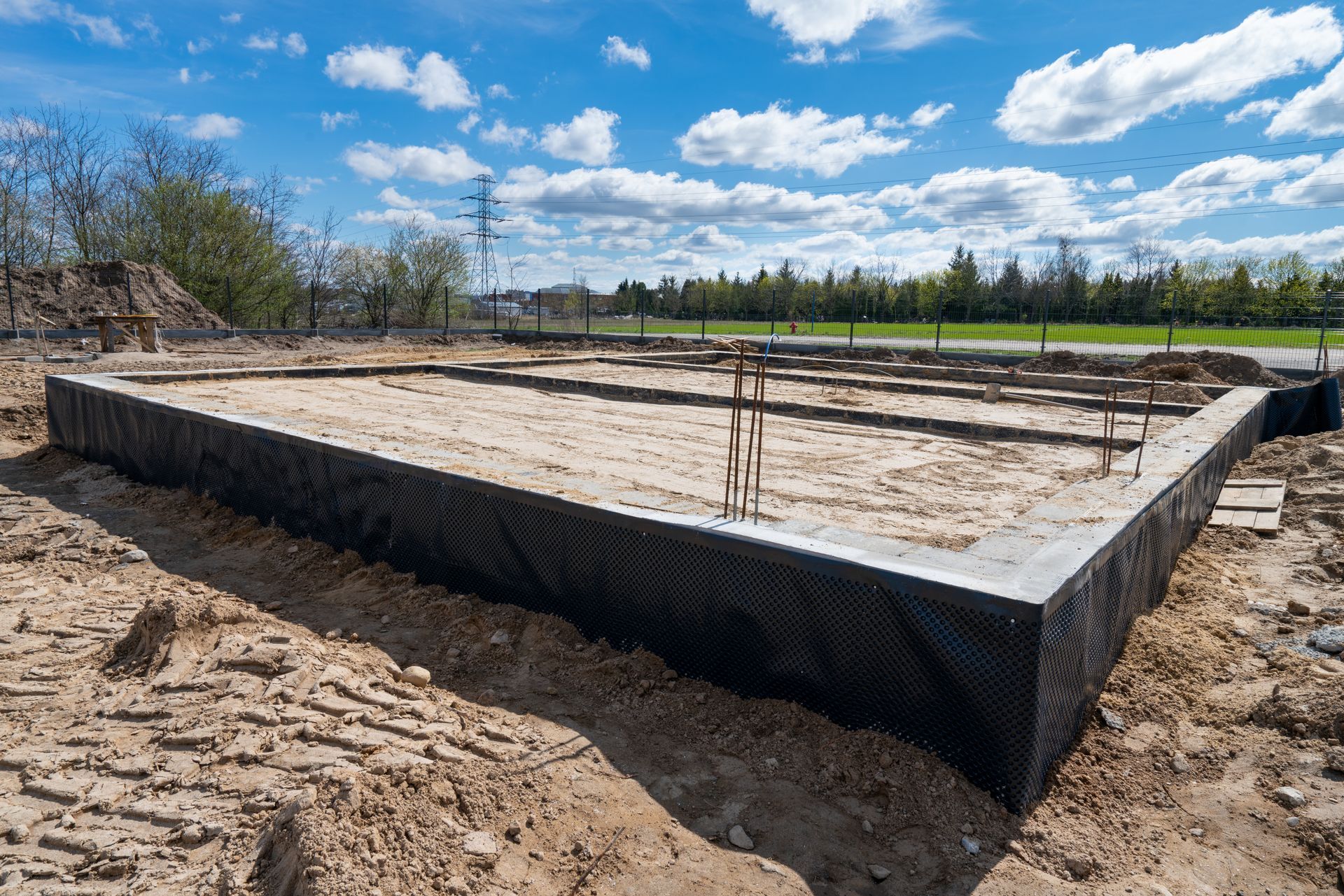 Person smoothing a curved concrete walkway beside a house during construction