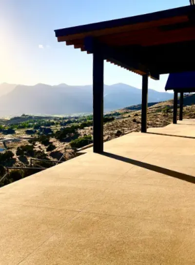 Sunlit desert-view patio with wooden beams and mountains in the distance