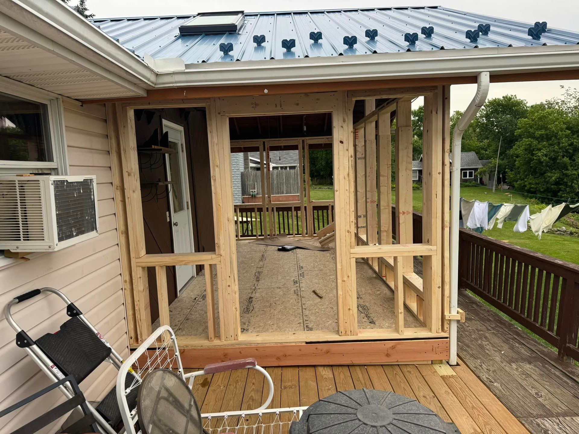 A screened in porch is being built on the side of a house