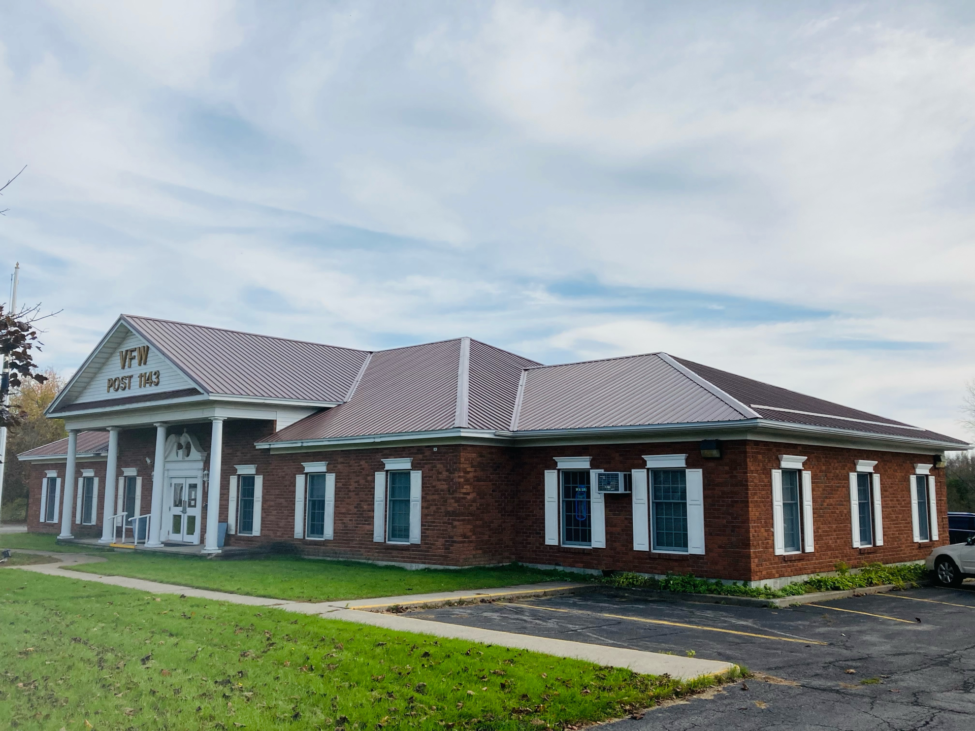 A large brick building with a gray roof and white windows.