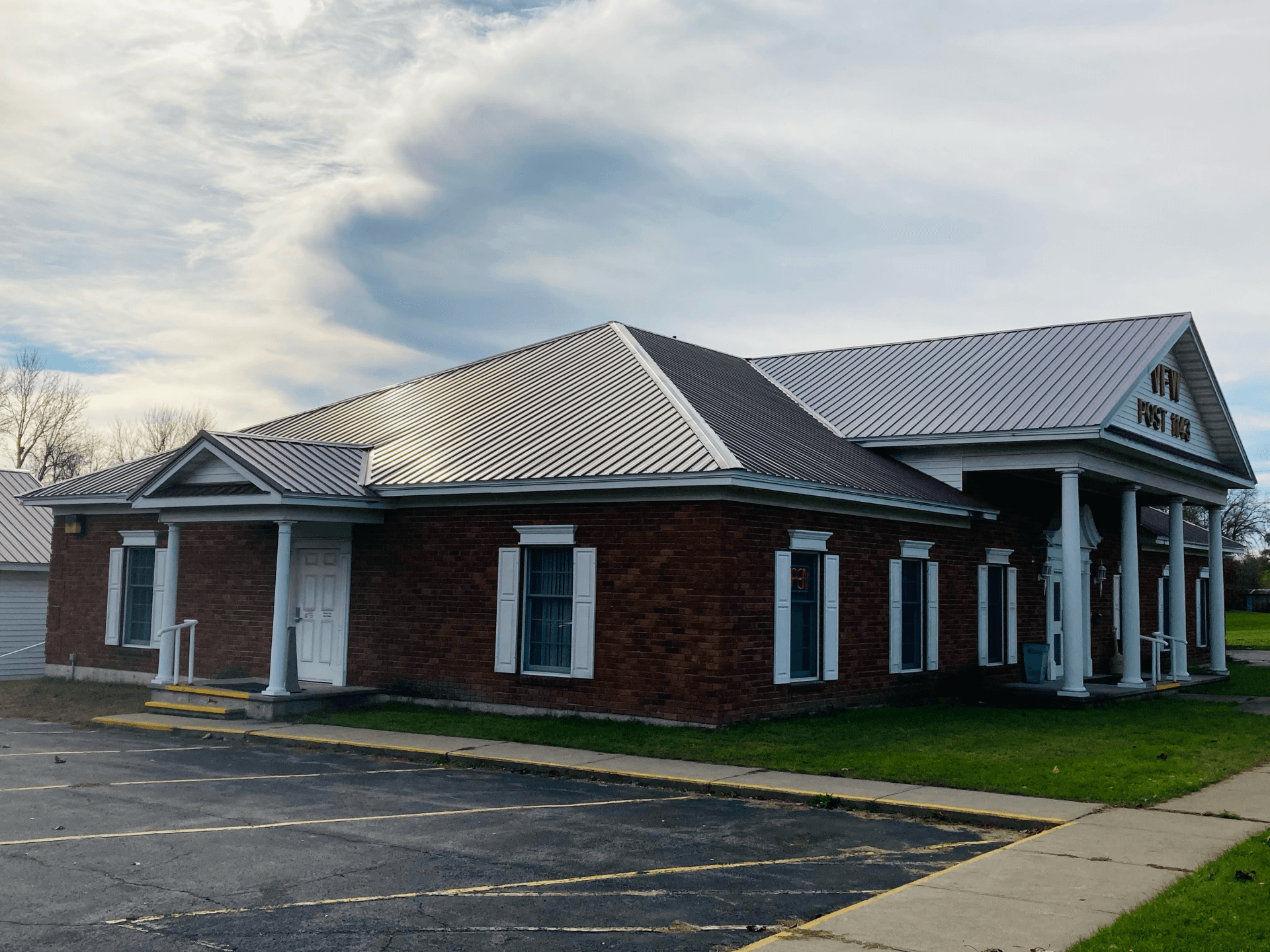 A large brick building with a white roof and columns