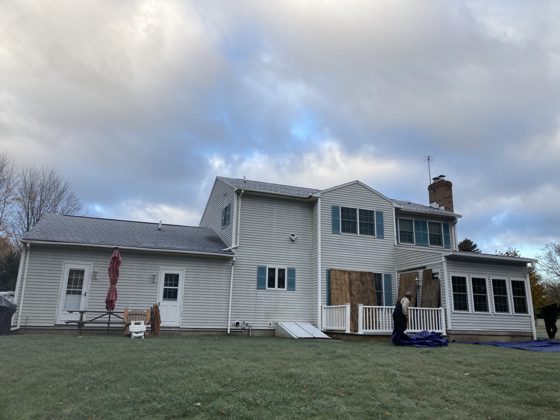 House under renovation with white siding, exposed wrap, and cloudy sky
