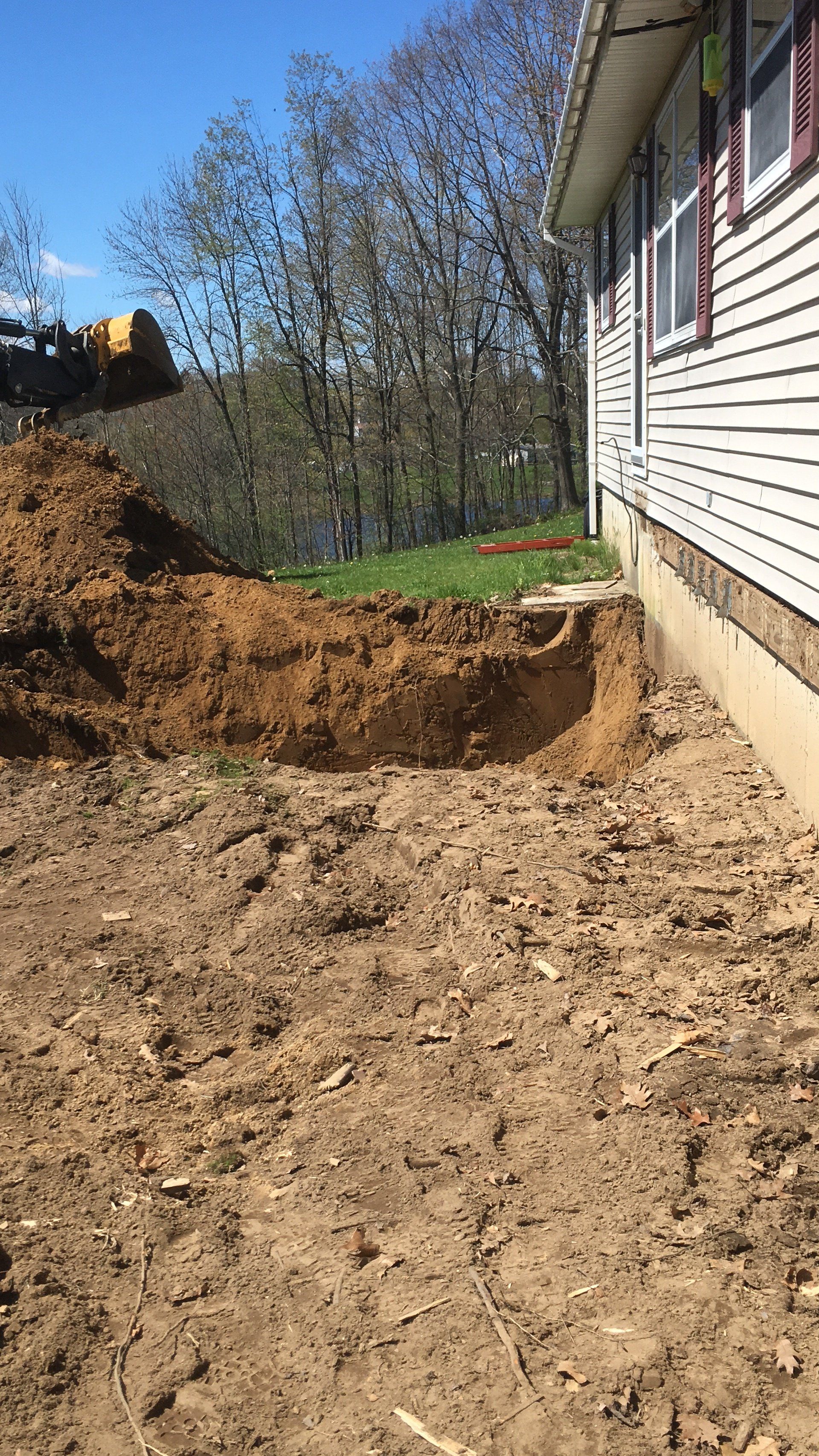 A large pile of dirt is sitting in front of a house.