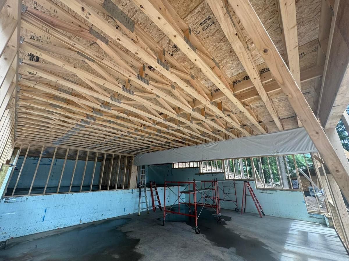 A garage under construction with wooden beams and a ladder.
