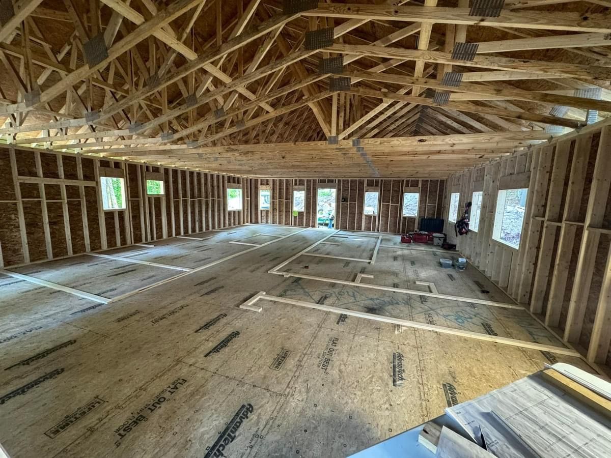 A large room with a lot of wooden beams and a lot of windows.