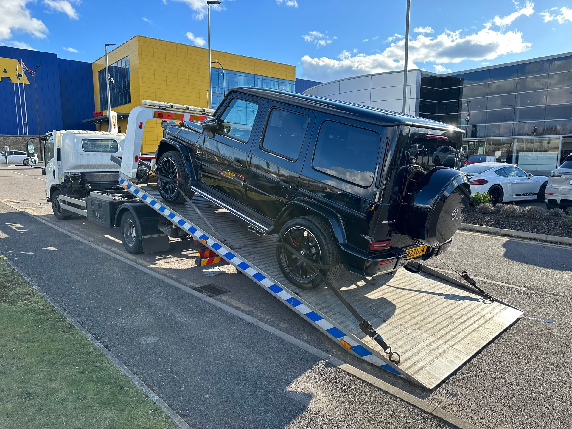 A black suv is being towed by a tow truck.