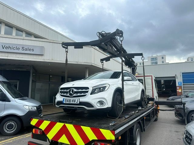 A yellow lamborghini urus is being towed by a tow truck.