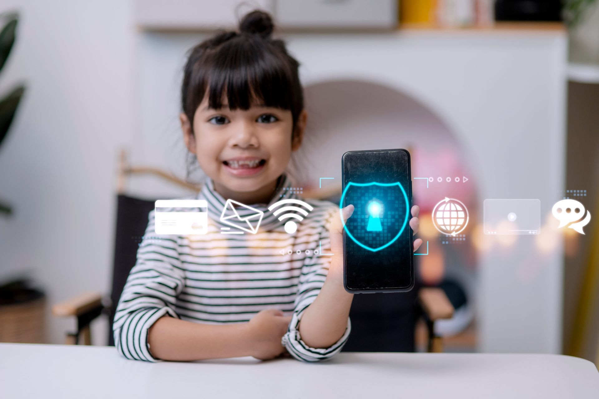 Child smiling at a table, holding a smartphone with glowing security icons hovering above it