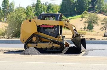 A bulldozer is sitting on the side of a road.