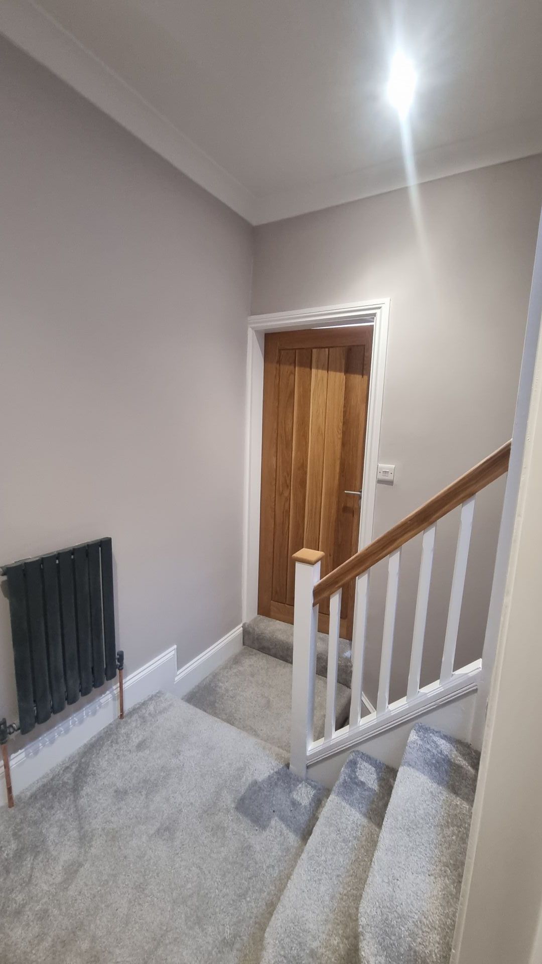 Renovated hallway with a wooden door and light grey walls providing a modern touch in York.