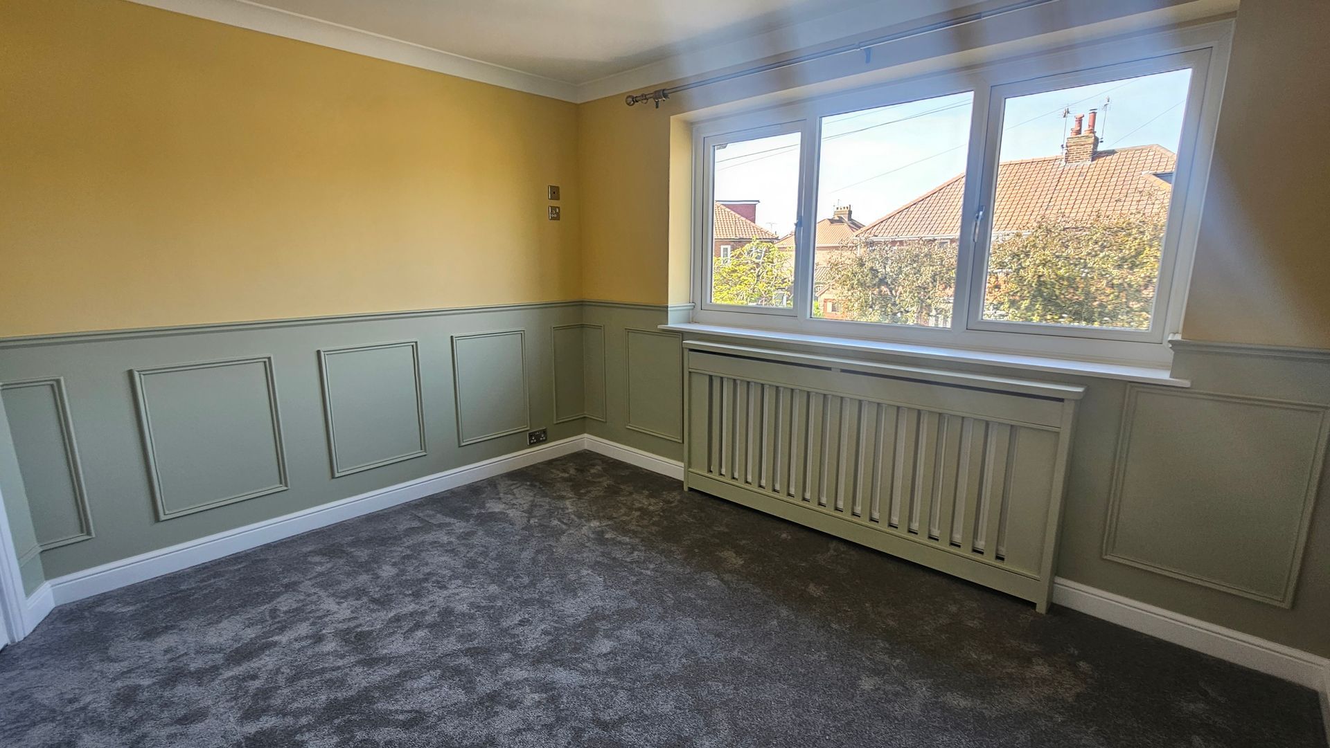 Stylishly decorated bedroom room with green panelling and yellow walls in York.