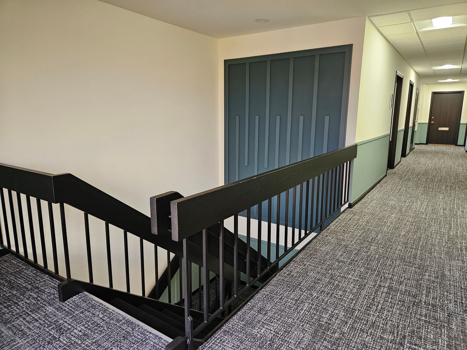 A hallway with stairs and a railing in a building