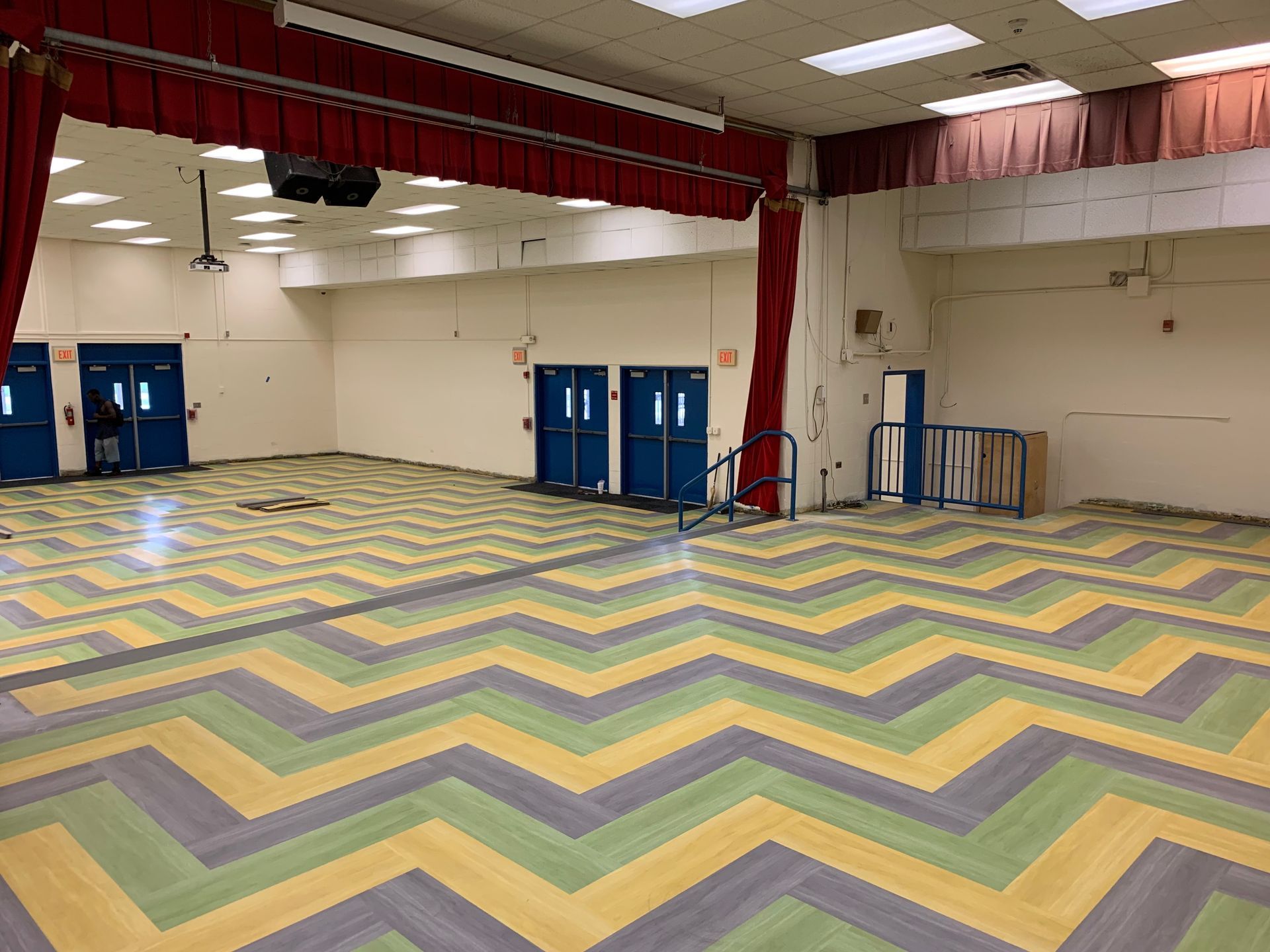 Chevron-pattern carpet tile installed in a school auditorium