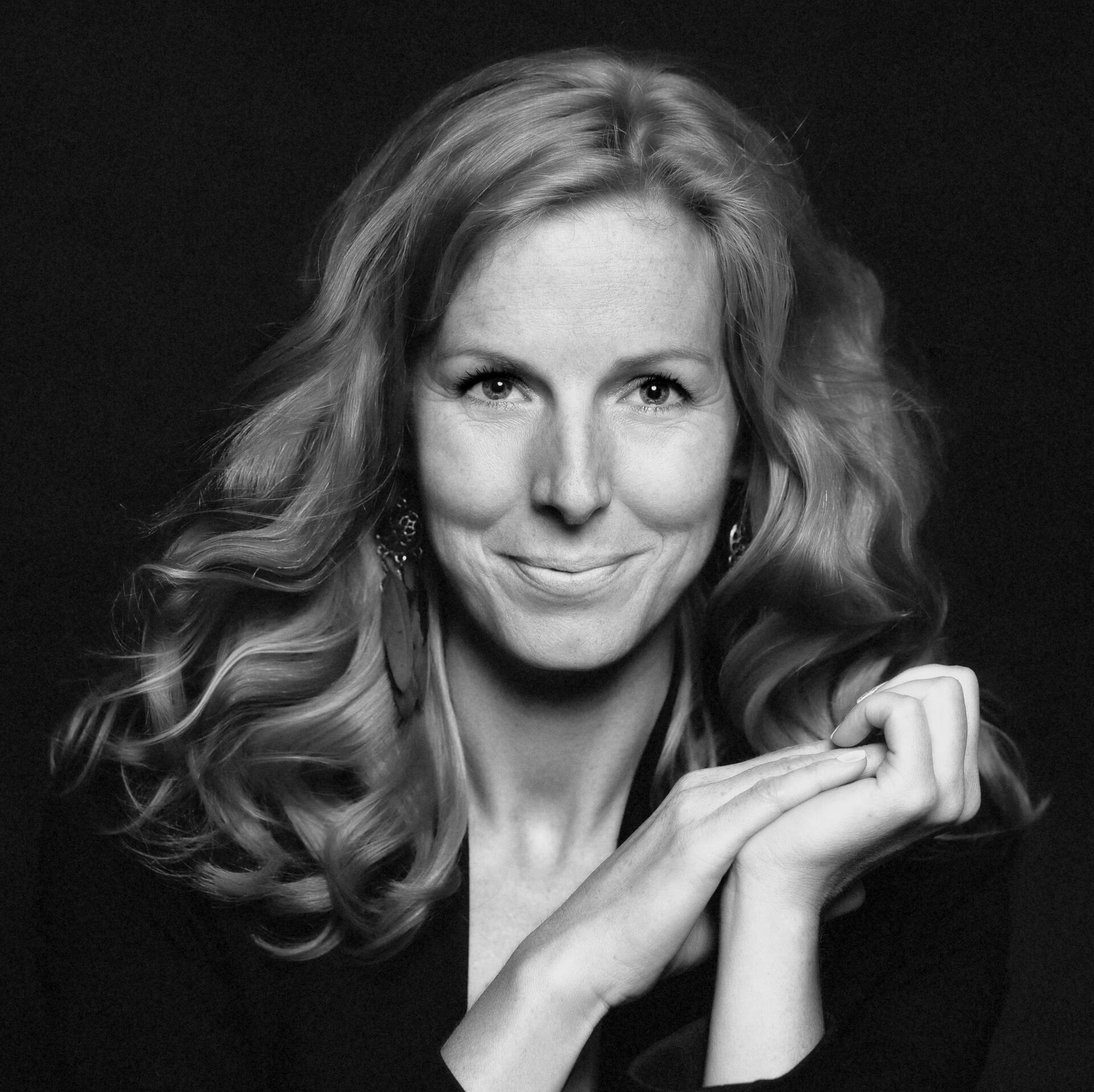 A black and white photo of a woman with her hands folded