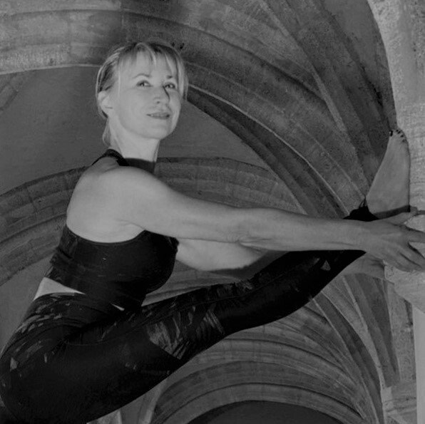 A woman is doing a yoga pose in a black and white photo.
