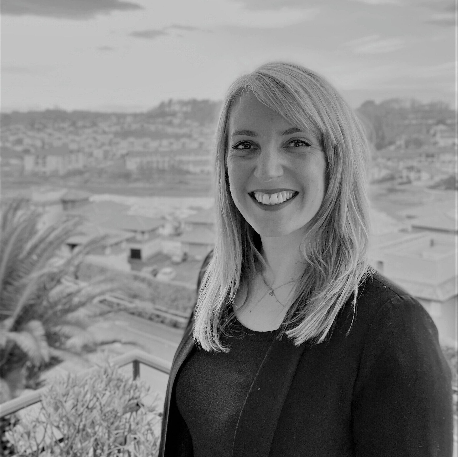 A woman is smiling in a black and white photo.