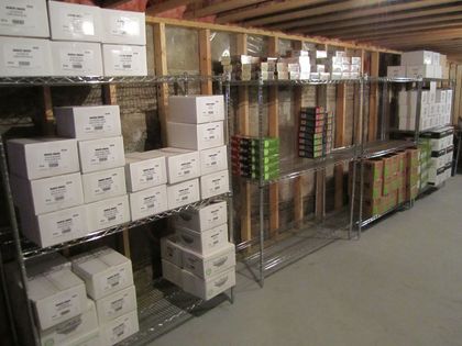 Warehouse storage shelves stocked with stacked boxes and rows of packaged goods