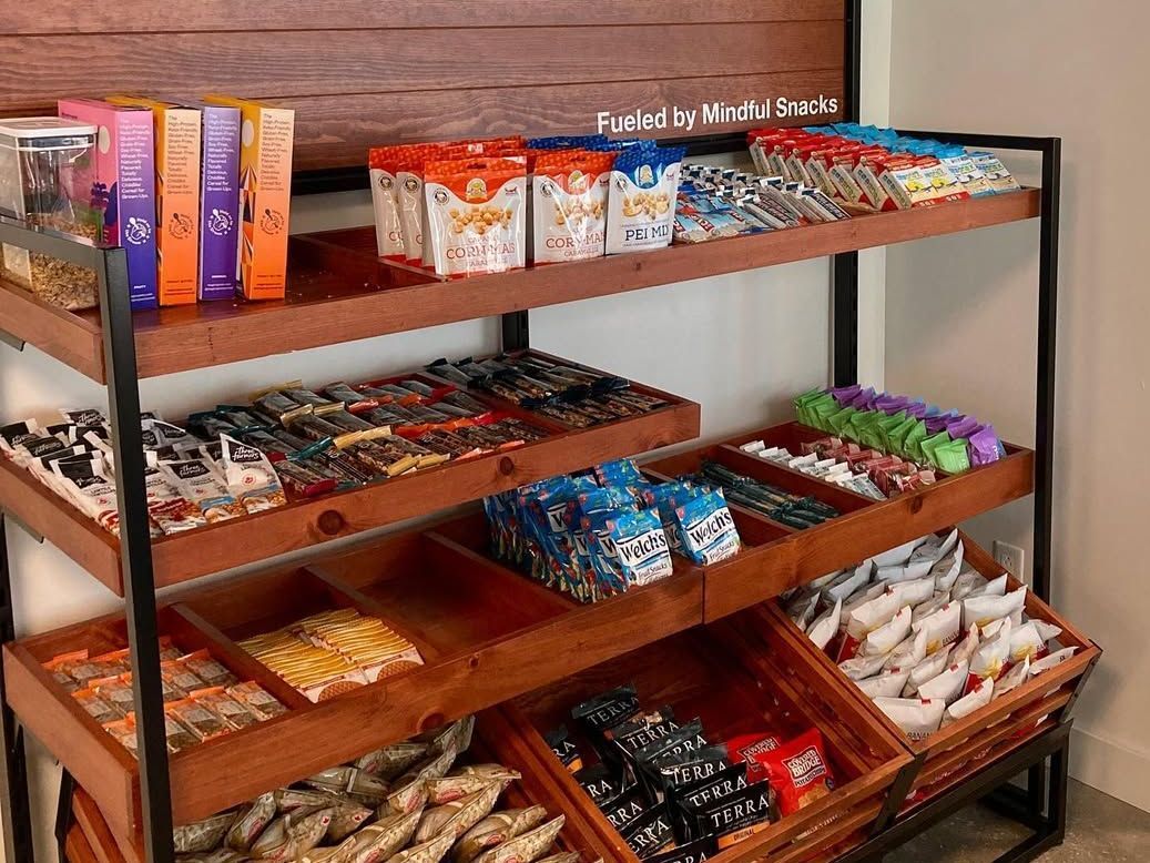 Metal display shelves filled with assorted candy bars and snack packs in a store aisle