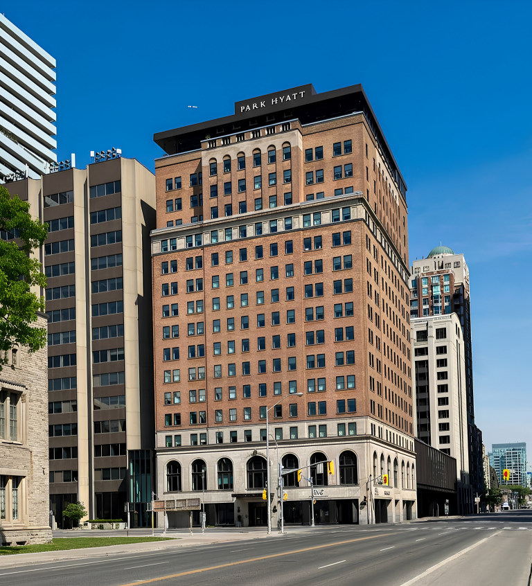 Park Hyatt hotel on a city street, a tall tan brick building against a clear blue sky