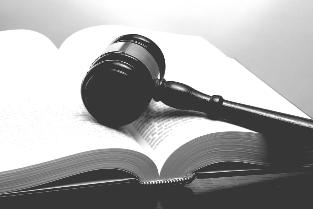 Wooden Gavel Kept On An Open Book, On Wooden Table — Farrell Lusher Solicitors In Wagga Wagga, NSW
