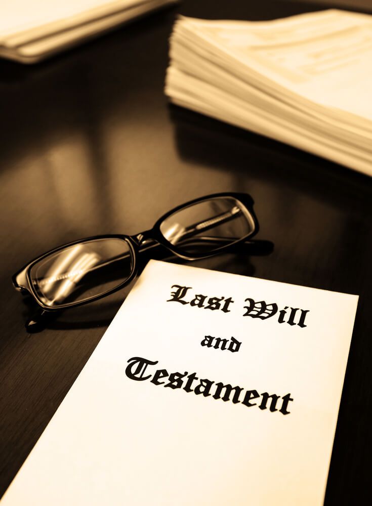 A Pair Of Glasses Rests On Top Of A Last Will And Testament — Farrell Lusher Solicitors In Wagga Wagga, NSW