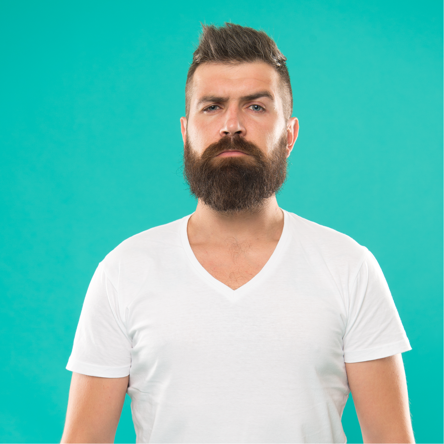A man with a beard and mustache is wearing a white t-shirt.