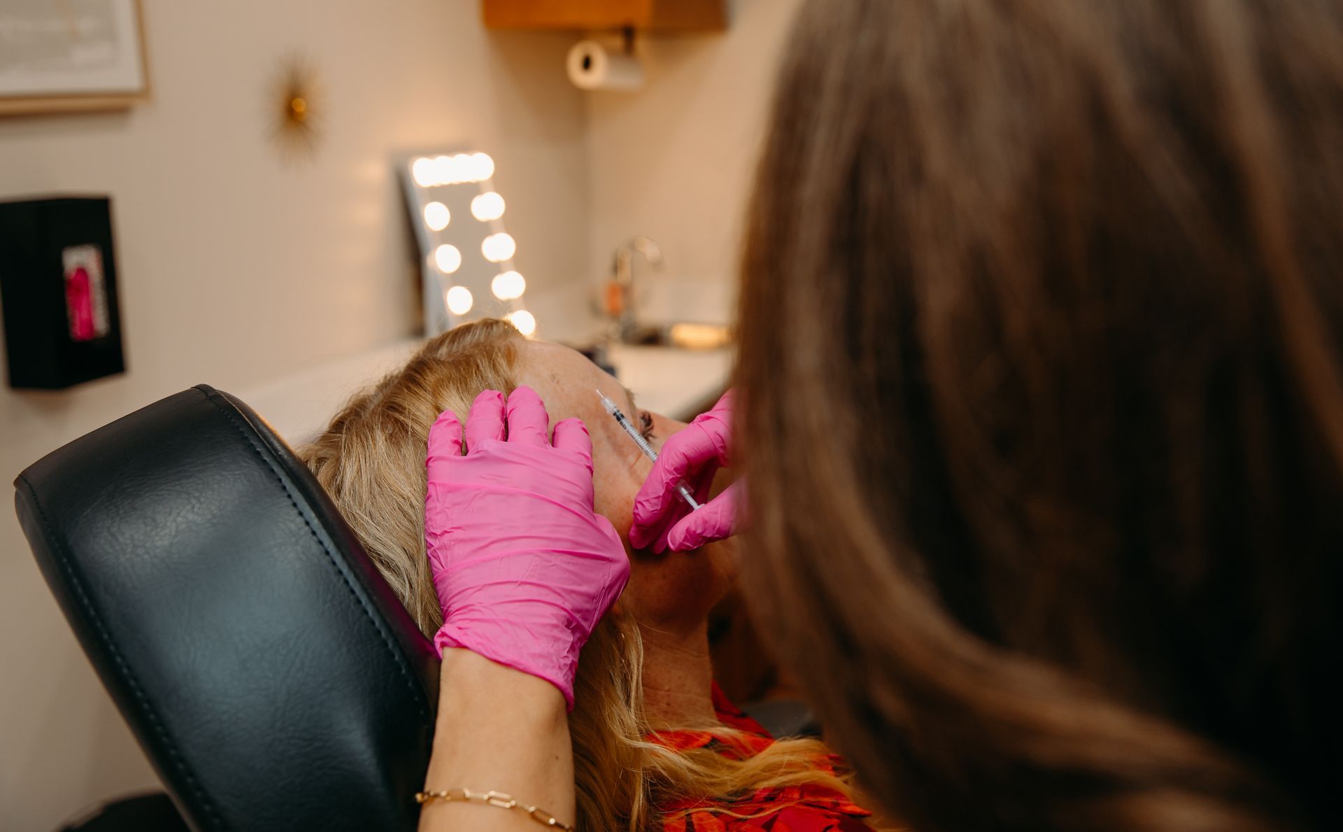 A woman is getting a botox injection in her face.