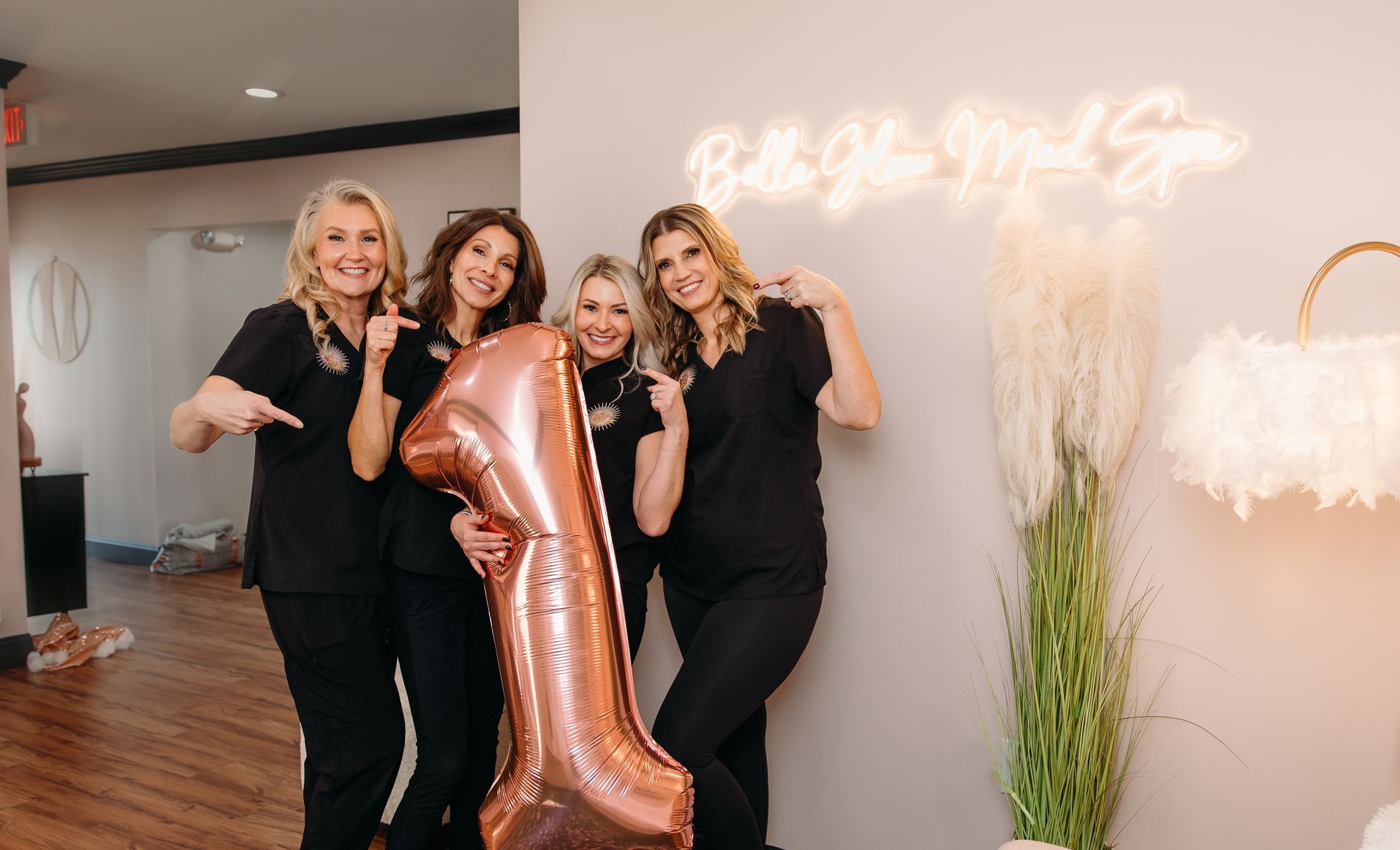 A group of women are standing next to each other holding balloons.