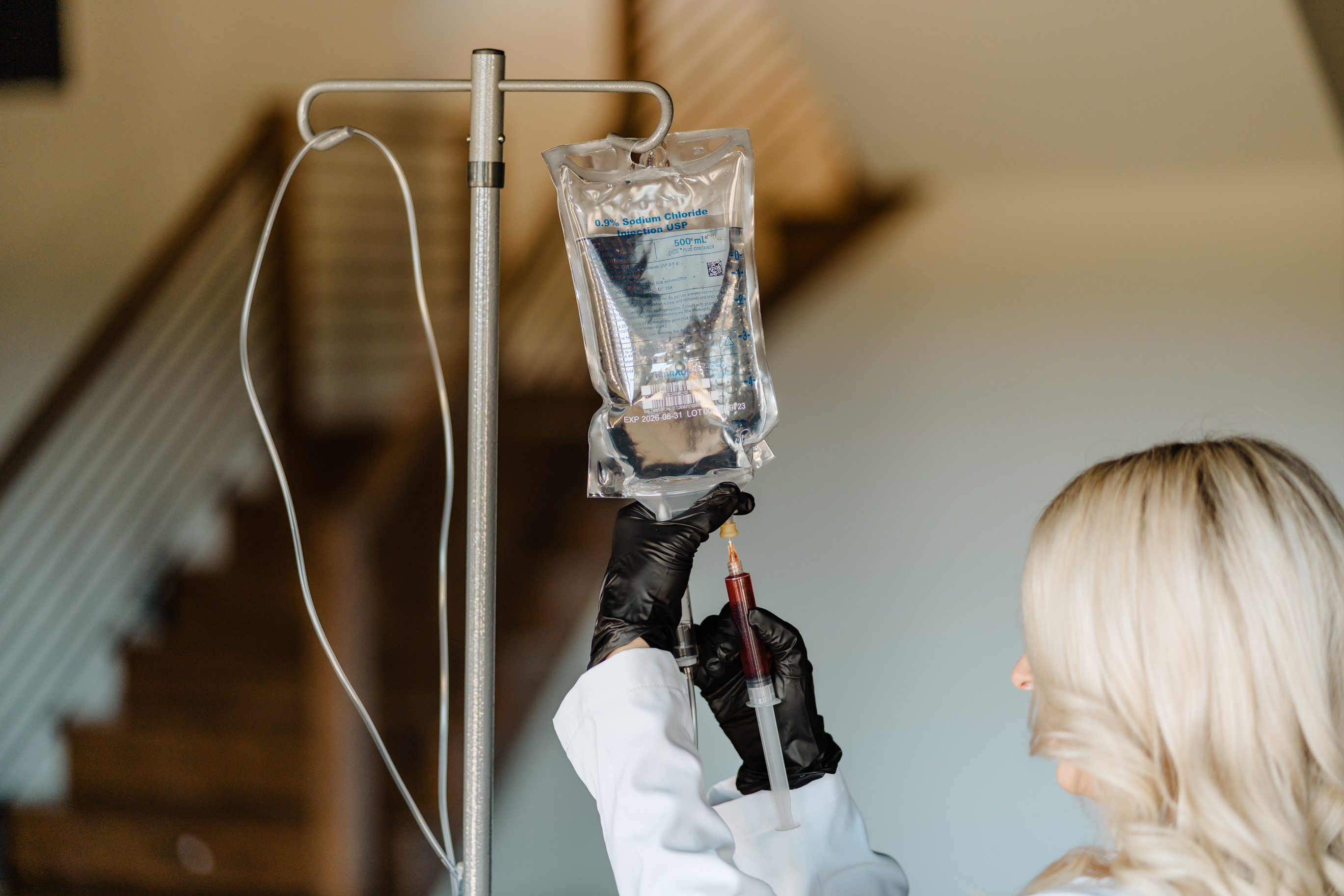A syringe filled with a yellow liquid on a pink background.
